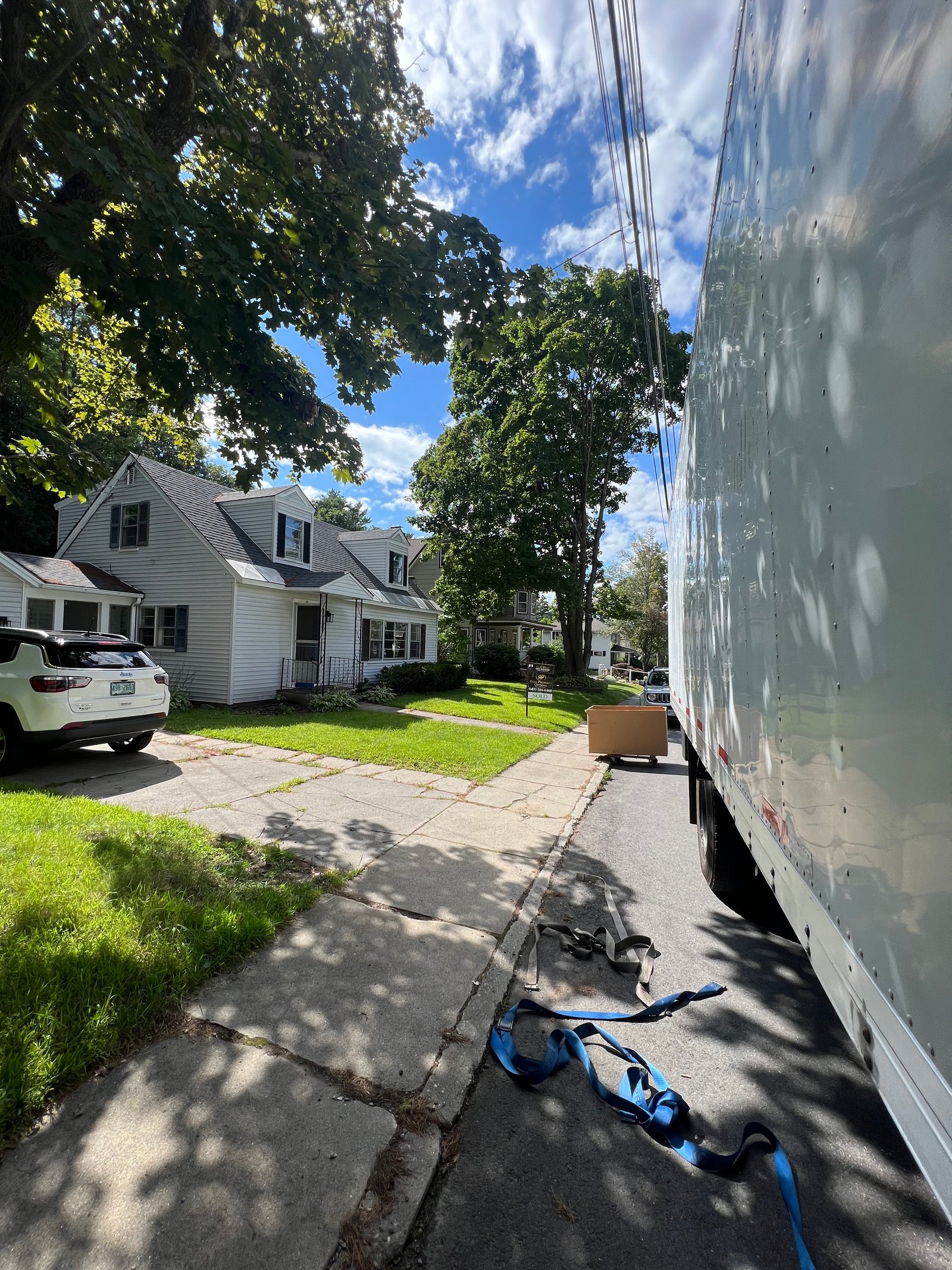 Moving truck parked beside a residential driveway during a New Hampshire move