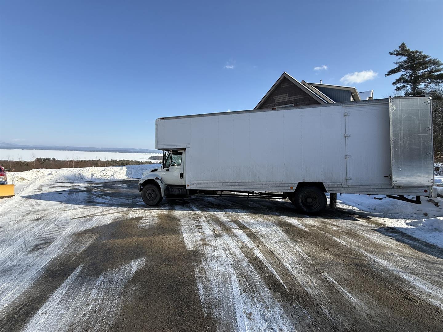 Dakota's White Glove Moving Service truck parked at a snowy New Hampshire property