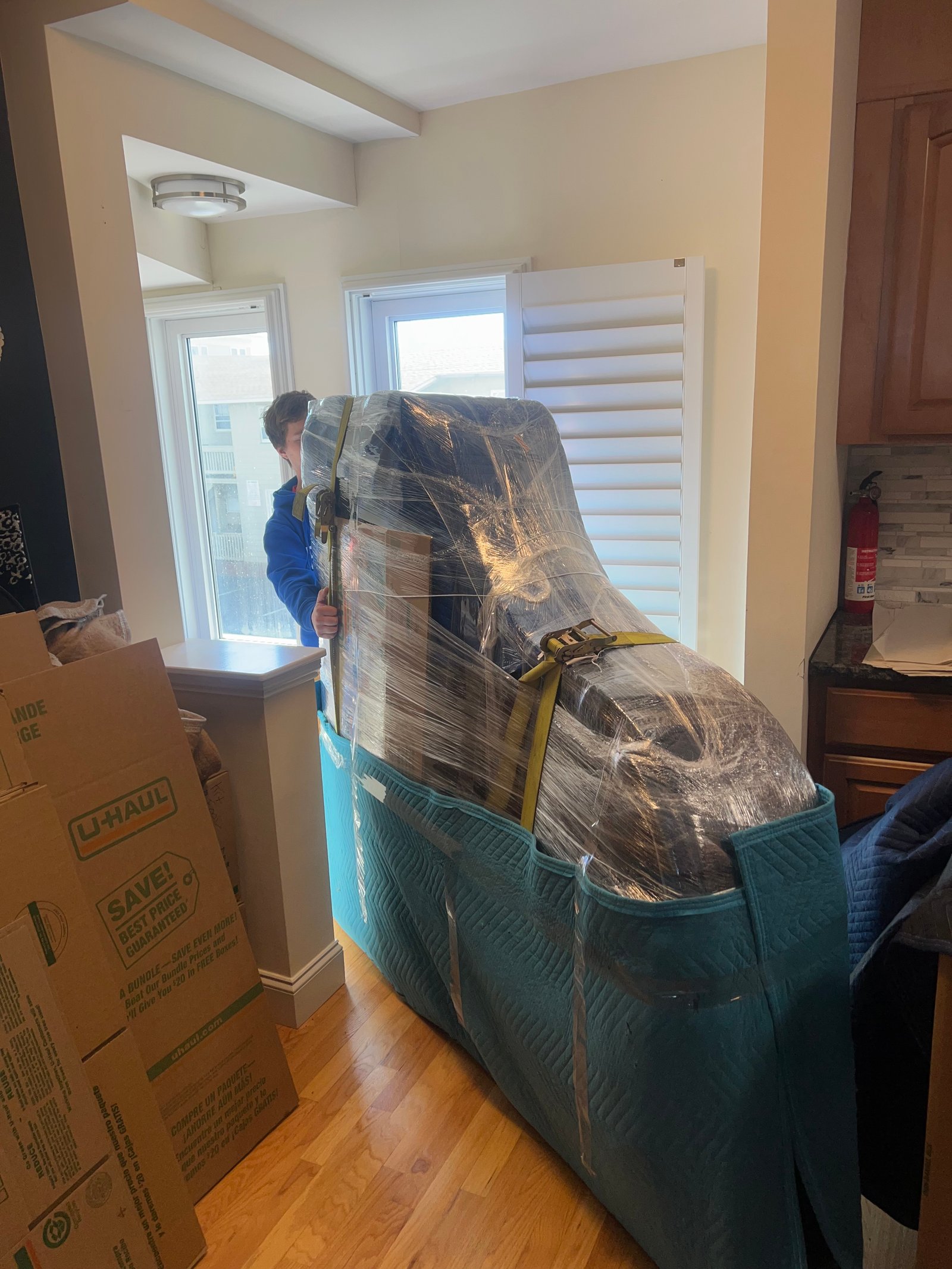 Piano wrapped with moving pads and shrink wrap for protected transport